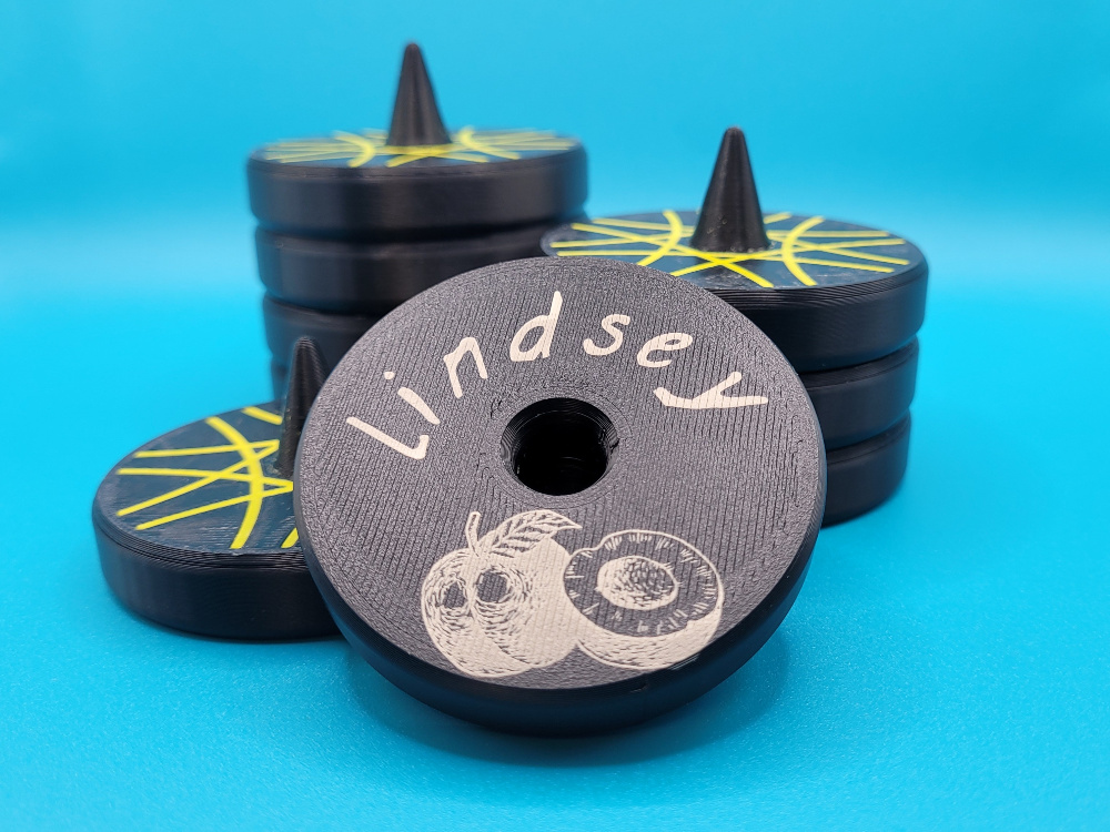 Sewing weights in a stack with one showing an embossed bottom image